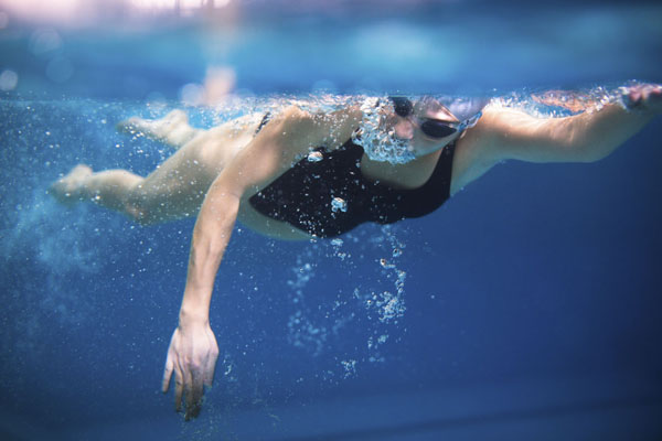 Female swimmer in an indoor swimming pool - doing crawl (shallow